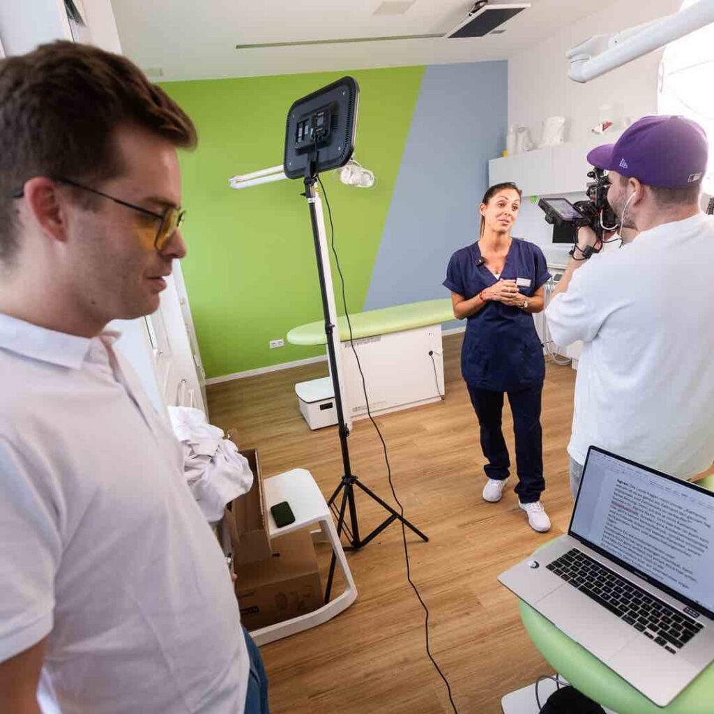 Zahnärztin bei der professionellen Videoproduktion in einer modern eingerichteten Zahnarztpraxis – Teil einer Social Media Marketing Kampagne für Zahnarztpraxen mit Kamera, Licht und Redaktionsskript.